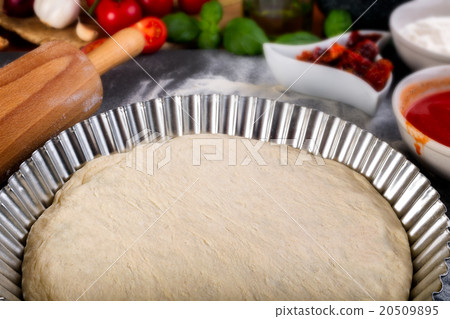 Prepering pizza dough for baking 20509895