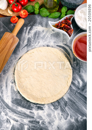 Prepering pizza dough for baking 20509896