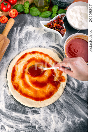 Prepering pizza dough for baking 20509897