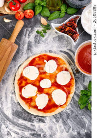 Prepering pizza dough for baking 20509898