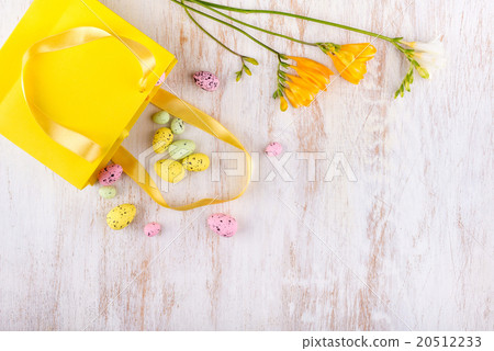 easter eggs and flowers over white wooden table 20512233