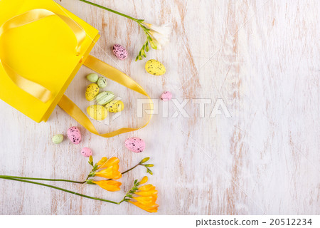easter eggs and flowers over white wooden table 20512234