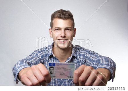 Young man showing off his driver license 20512633