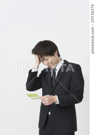 A businessman who declines looking at passbook A businessman who declines looking at passbook 20516378