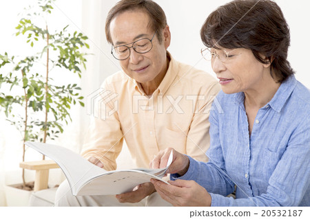 Senior couple looking at mail-order catalog together 20532187