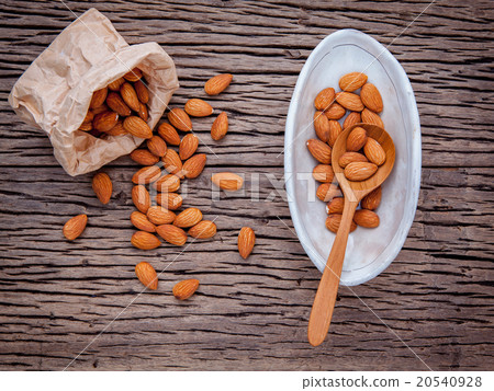 Almonds in brown paper bag and white bowl. Almonds in brown paper bag and white bowl. 20540928