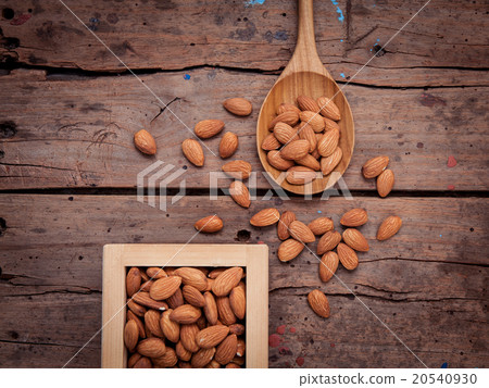 Almonds in wooden box and wooden spoon . Almonds in wooden box and wooden spoon . 20540930