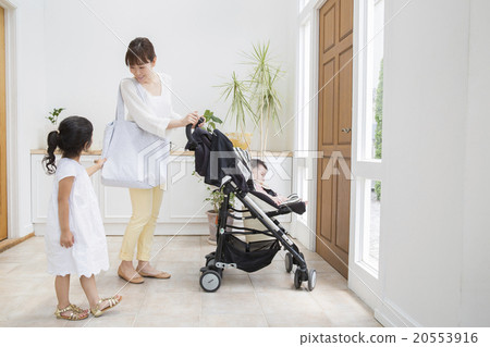 A baby riding a stroller and a mother and a girl A baby riding a stroller and a mother and a girl 20553916