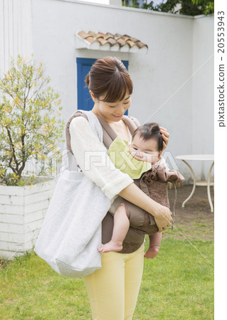 Mother hugging a baby walking outside 20553943