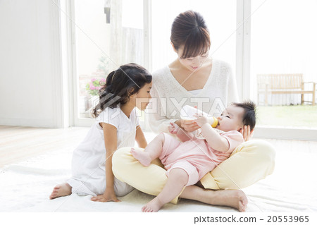 A mother and a girl who gives milk to a baby 20553965