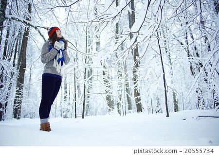 Adult girl in a sweater in the winter snowy forest Adult girl in a sweater in the winter snowy forest 20555734