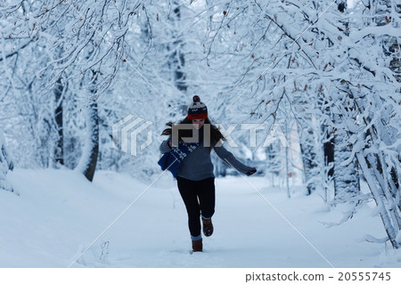 Girl running in winter park snow vacation 20555745
