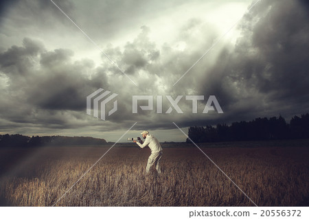 photographer with a camera in the bad weather the storm 20556372