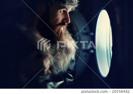 man looking through a porthole of a ship man looking through a porthole of a ship 20556482