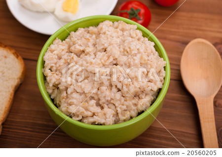Oatmeal in a bowl on the wooden table. 20560205