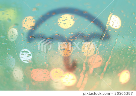 Rain drops and umbrella on window with light bokeh 20565397