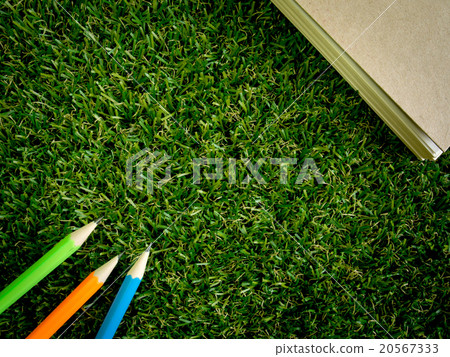 Book and colorful pencil on green artificial grass Book and colorful pencil on green artificial grass 20567333