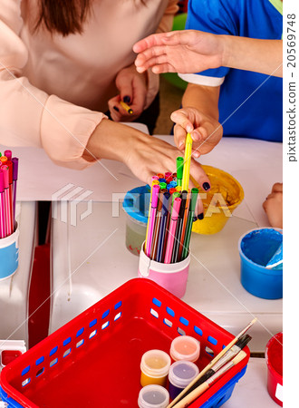 Group of kids hands painting picture on desk .  20569748