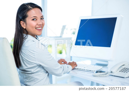 Smiling businesswoman working on computer 20577187
