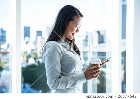 Smiling businesswoman using smartphone Smiling businesswoman using smartphone 20577642