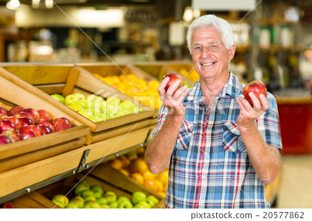 Smiling senior man holding apples Smiling senior man holding apples 20577862