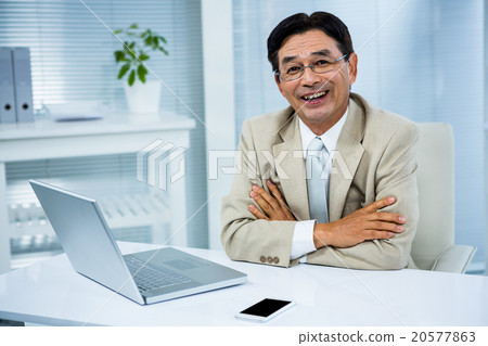 Smiling businessman with crossed arms Smiling businessman with crossed arms 20577863