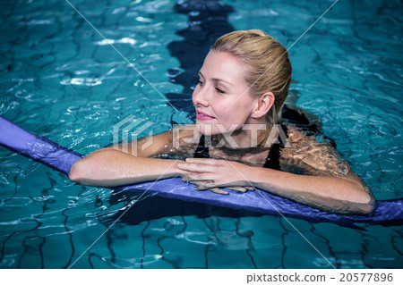 Fit smiling woman with a foam roller 20577896