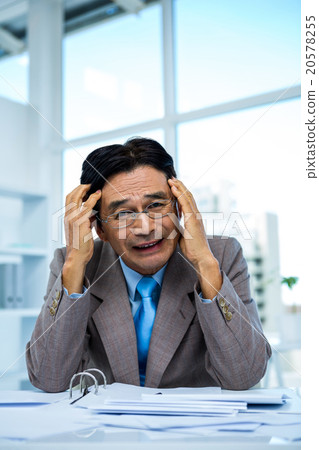 Worried businessman working at his desk 20578255