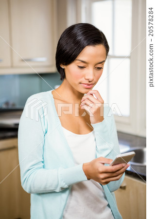Thoughtful brunette using smartphone Thoughtful brunette using smartphone 20578284
