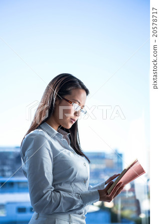 Concentrated businesswoman reading book 20578717