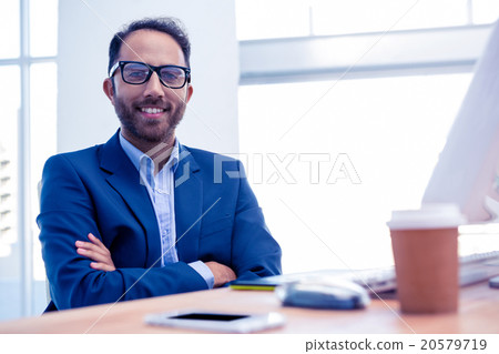 Portrait of happy businessman with arms crossed in office Portrait of happy businessman with arms crossed in office 20579719