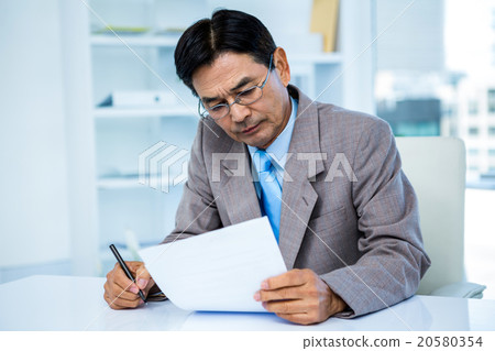 Businessman looking at document 20580354