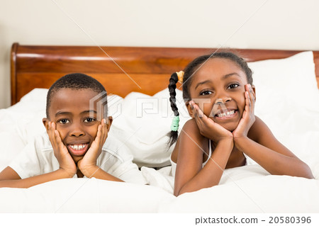Portrait of happy siblings in bed Portrait of happy siblings in bed 20580396