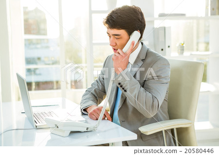 Asian businessman talking on the telephone Asian businessman talking on the telephone 20580446