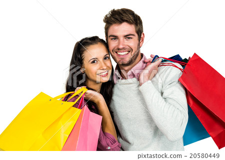 Portrait of smiling couple holding bags 20580449