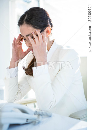 Stressed businesswoman working at her desk 20580494