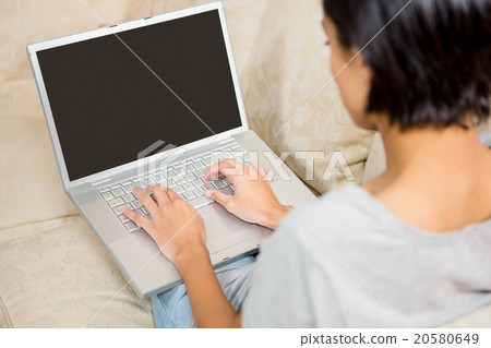Over shoulder view of brunette using laptop Over shoulder view of brunette using laptop 20580649
