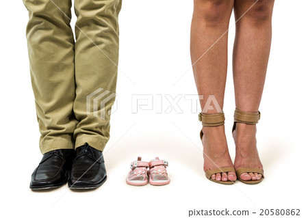 Low section of man and woman amidst baby shoes 20580862