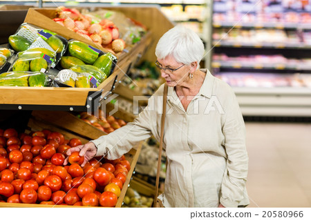 Senior woman choosing her tomatoes Senior woman choosing her tomatoes 20580966
