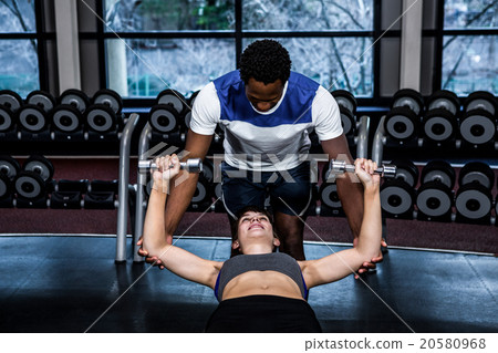 Male trainer assisting fit woman Male trainer assisting fit woman 20580968