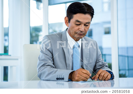 Businessman writing on paper 20581058
