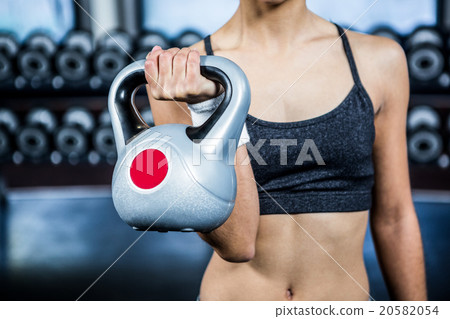 Cropped image of fit woman lifting kettlebell Cropped image of fit woman lifting kettlebell 20582054