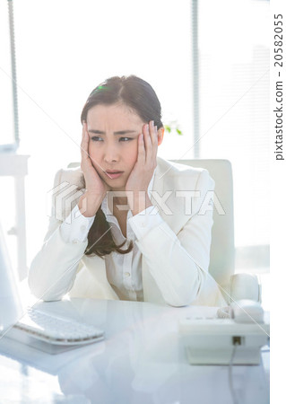 Stressed businesswoman working at her desk Stressed businesswoman working at her desk 20582055