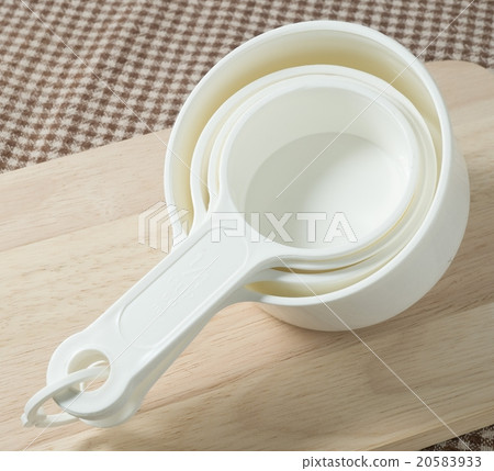 Four Plastic Measuring Cups on Cutting Board 20583933