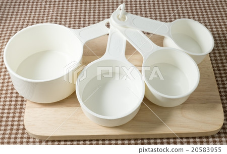 Four Plastic Measuring Cups on Wooden Board Four Plastic Measuring Cups on Wooden Board 20583955