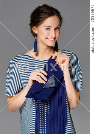 lady in dress in stripes posing in studio with bag 20586673