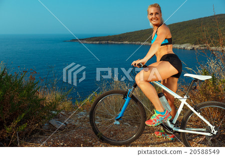 Woman cyclist on a mountain bike looking at the landscape of mou Woman cyclist on a mountain bike looking at the landscape of mou 20588549