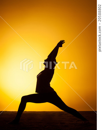The woman practicing yoga in the sunset light 20588802