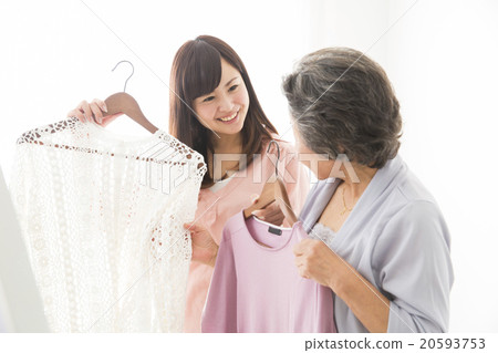 選擇衣服的高級婦女和年輕婦女 20593753