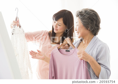 選擇衣服的高級婦女和年輕婦女 20593754